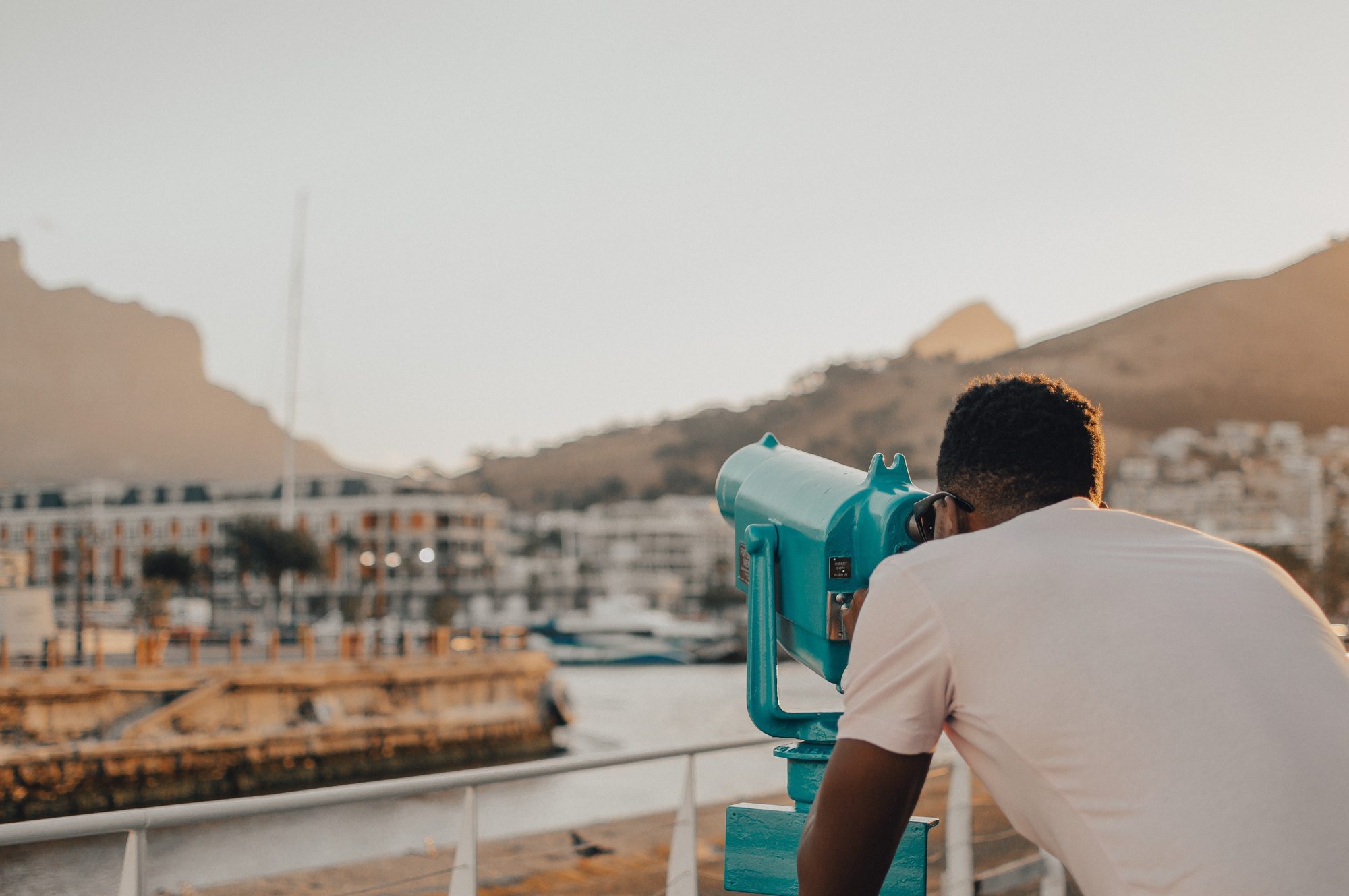 A young man looking through a telescope in Cape Town