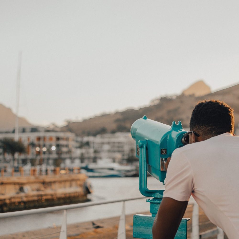 A young man looking through a telescope in Cape Town